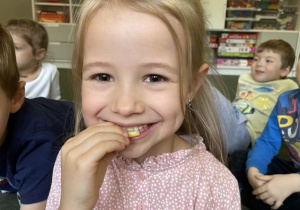 dziecko próbuje się uśmiechać podczas jedzenia cytryny